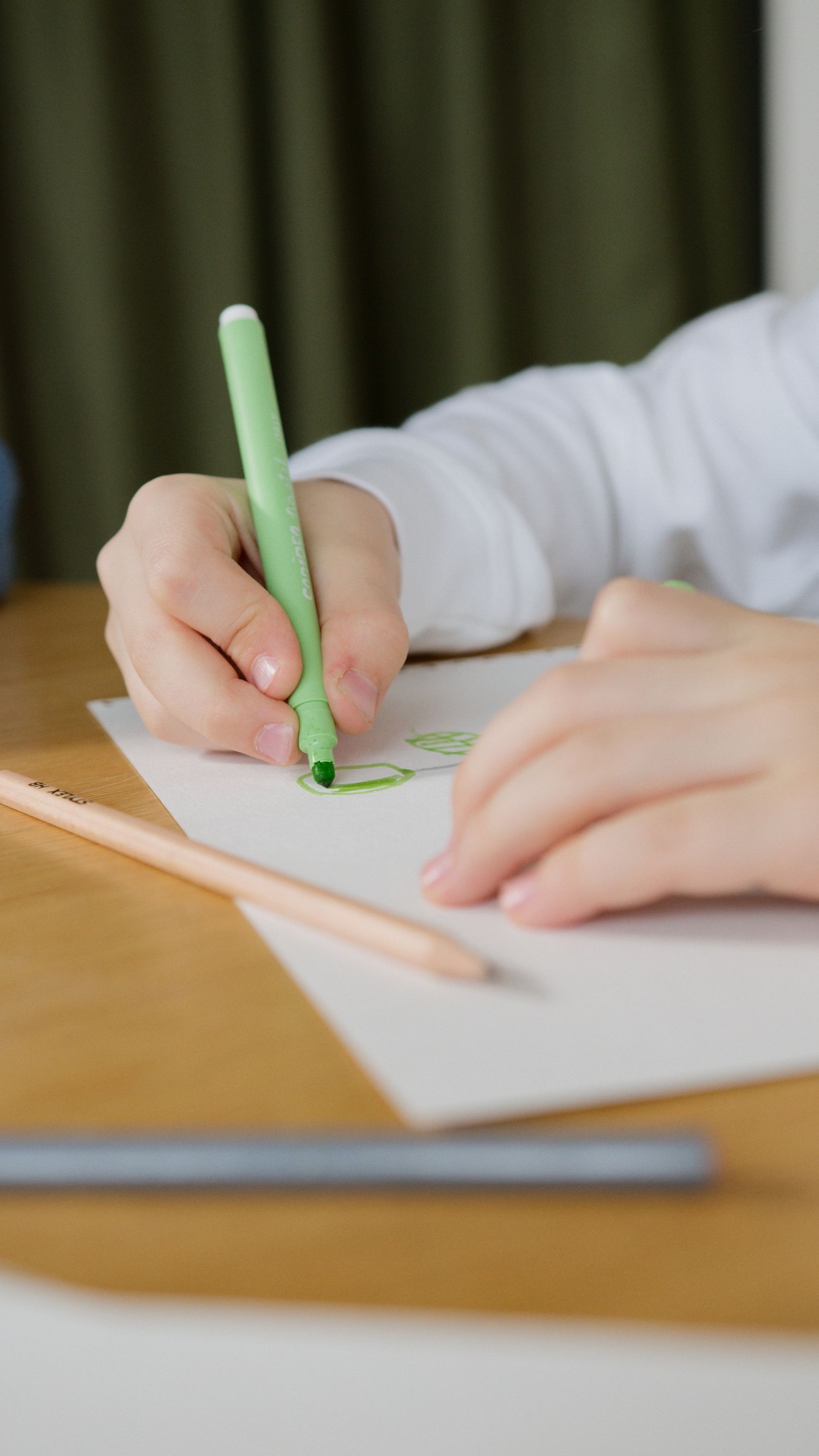 Kind tekent met een groene stift